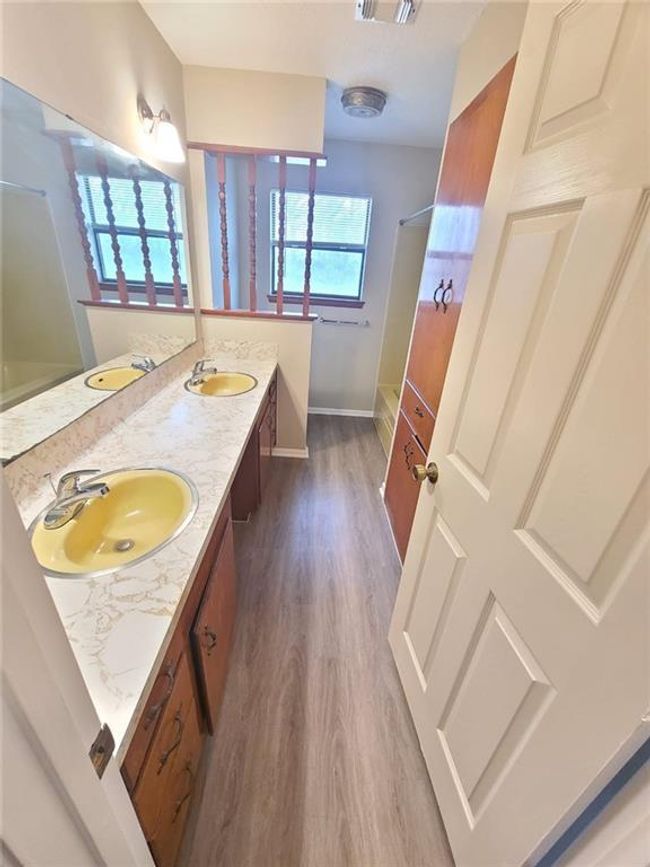 Full bath featuring double vanity, wood finished floors, and washtub / shower combination | Image 15