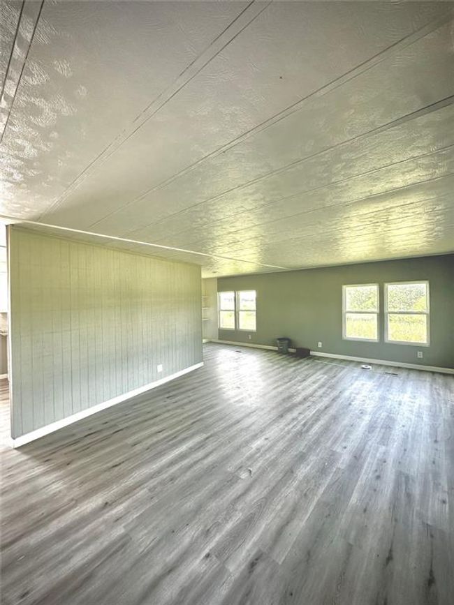 Unfurnished living room featuring wood finished floors and baseboards | Image 4