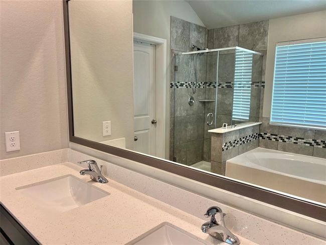 Experience luxury with a spacious glass and tile shower complemented by elegant dual vanities. | Image 14