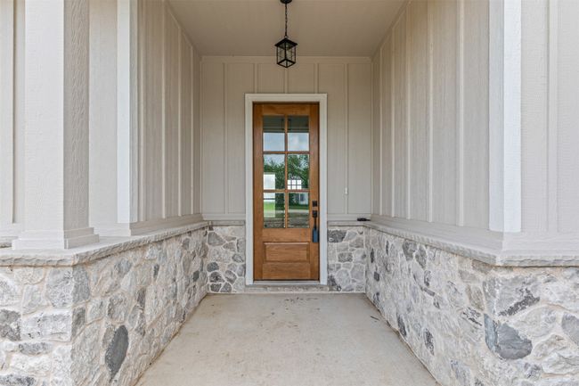 Doorway to property featuring stone siding | Image 6