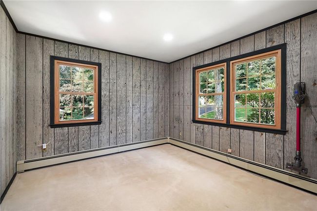 Spare room featuring wood walls, carpet flooring, and plenty of natural light | Image 13