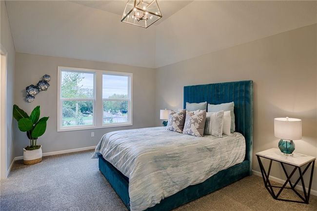 Carpeted bedroom featuring a chandelier and vaulted ceiling | Image 38