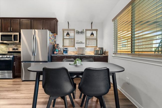 Kitchen featuring dark brown cabinetry, light wood-style floors, stainless steel appliances, and a healthy amount of sunlight | Image 14