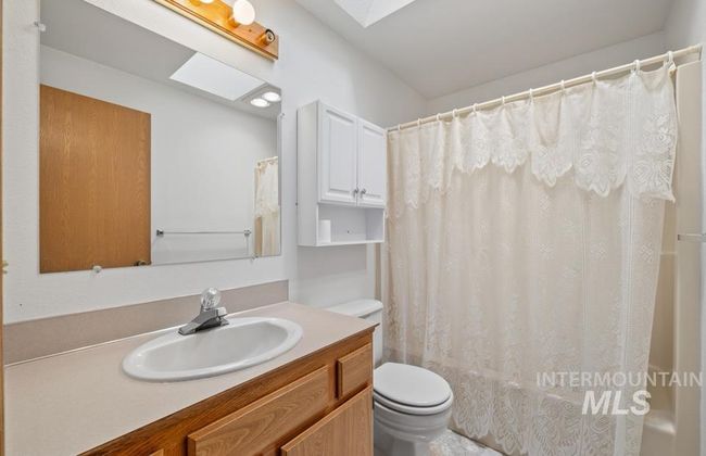 Bathroom featuring vanity and shower / bathtub combination with curtain | Image 14