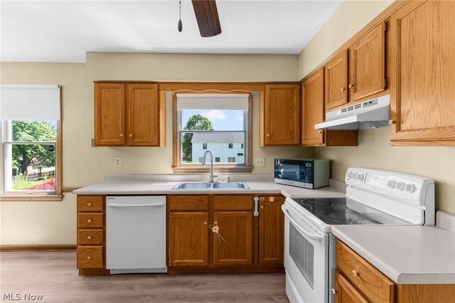 Kitchen with white appliances, sink, a healthy amount of sunlight, and hardwood / wood-style flooring | Image 10