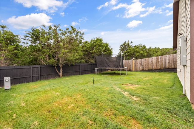 Fenced backyard with a trampoline | Image 34