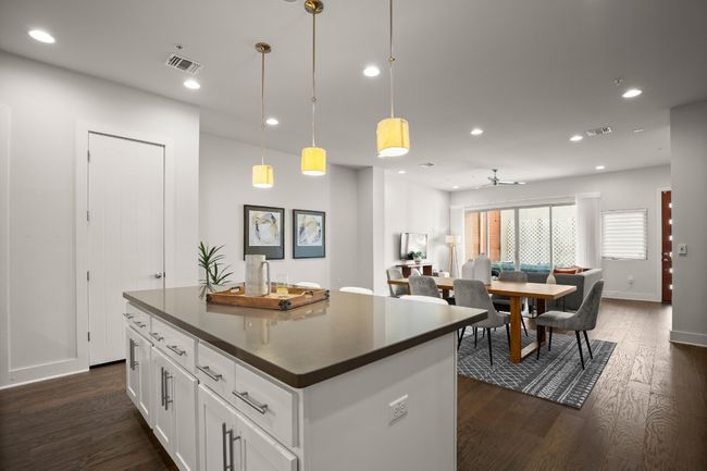 Kitchen with dark countertops, recessed lighting, a kitchen island, dark wood finished floors, and white cabinetry | Image 8