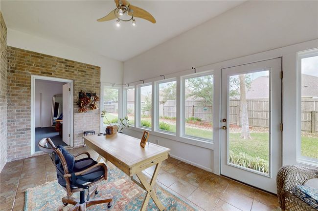 Office area with brick wall, ceiling fan, and a healthy amount of sunlight | Image 14