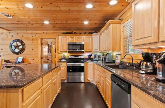 Kitchen featuring appliances with stainless steel finishes, light brown cabinets, a sink, recessed lighting, and wood ceiling | Image 10