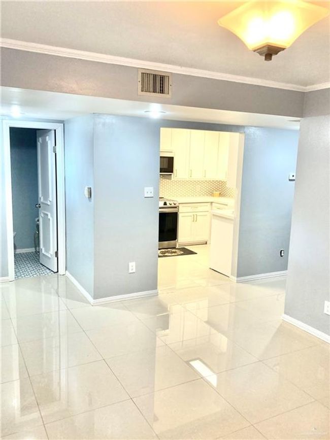 Spare room featuring light tile patterned flooring and ornamental molding | Image 4