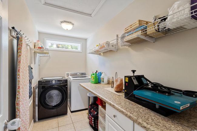 Washroom with washer and dryer and light tile patterned floors | Image 31