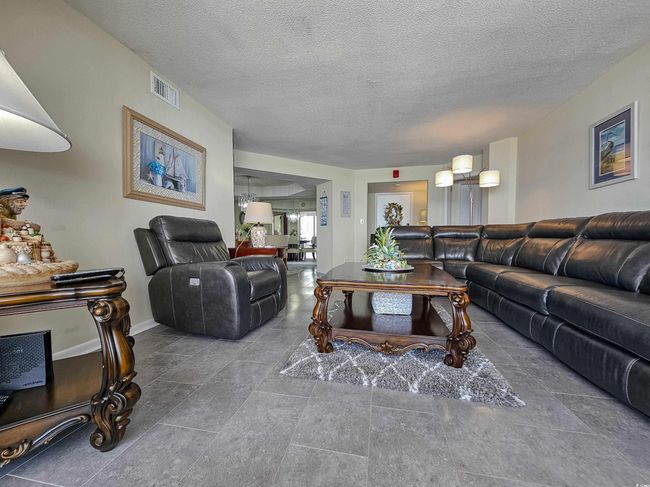 Living room featuring a textured ceiling and baseboards | Image 6