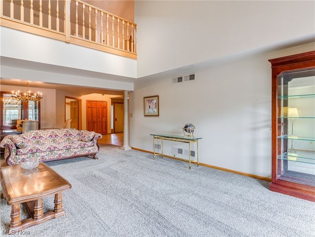 Living room with light carpet and a high ceiling | Image 11