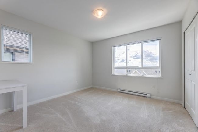 Unfurnished bedroom with baseboard heating, carpet floors, and a closet | Image 23