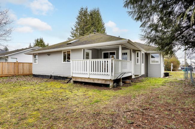 Back of property featuring roof with shingles, a wooden deck, fence, and a yard | Image 18