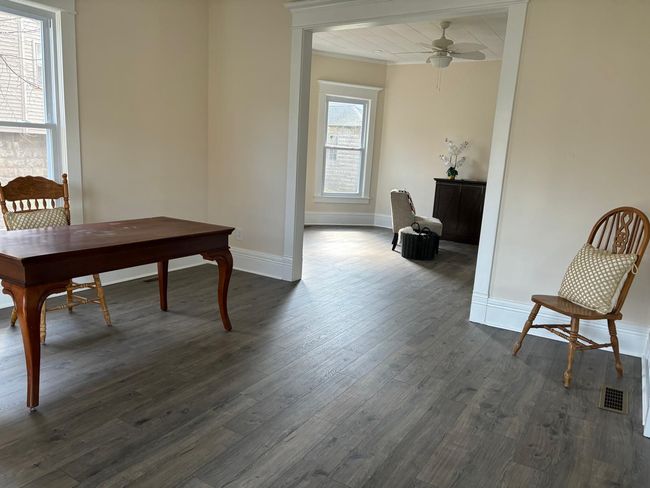 Dining room with dark wood-type flooring, baseboards, and ceiling fan | Image 10