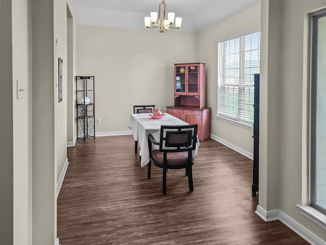 Dining area featuring a chandelier and dark wood-style flooring | Image 13