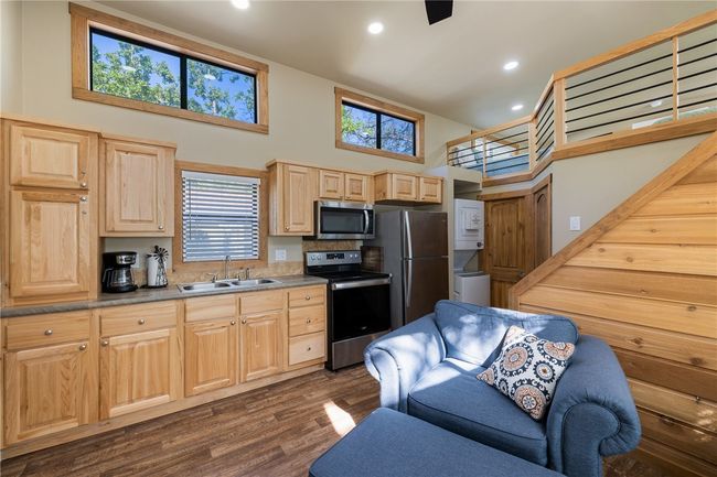 Kitchen with dark wood finished floors, light brown cabinetry, recessed lighting, a sink, and stainless steel appliances | Image 8