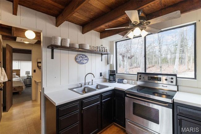 Kitchen featuring a sink, beamed ceiling, wood ceiling, electric range, and open shelves | Image 16