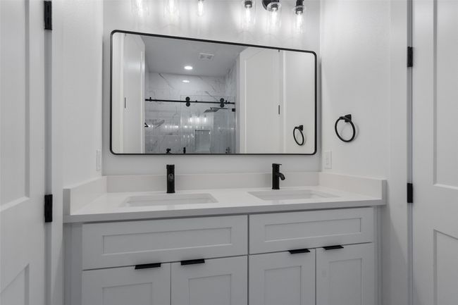 Full bathroom featuring a marble finish shower and double vanity | Image 8