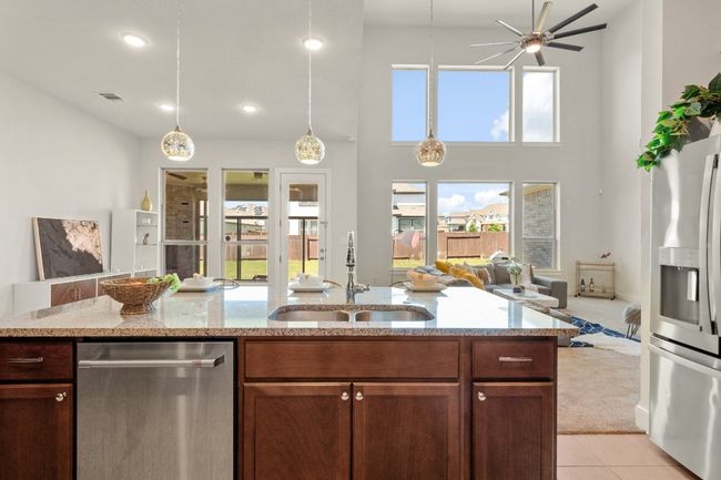 Kitchen featuring a ceiling fan, a sink, open floor plan, light tile patterned floors, and appliances with stainless steel finishes | Image 11