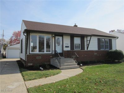 View of front of home featuring a front yard, a garage, and an outbuilding | Image 1