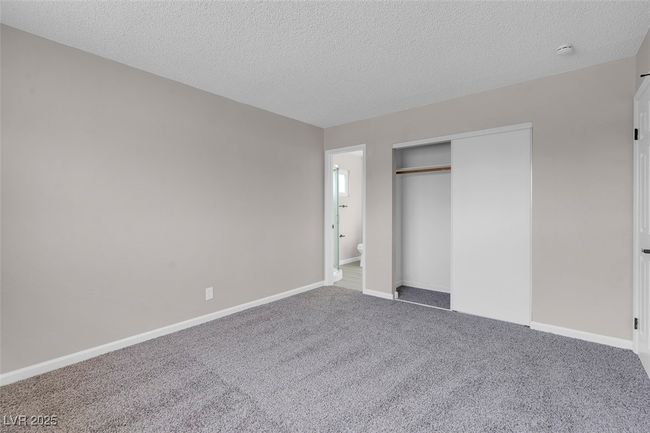 Unfurnished bedroom with baseboards, carpet flooring, a textured ceiling, and a closet | Image 22