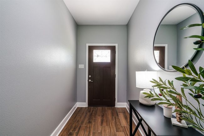 Doorway to outside featuring baseboards and dark wood-type flooring | Image 5