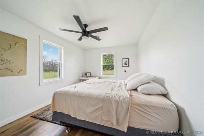 Bedroom with wood finished floors, baseboards, and a ceiling fan | Image 25
