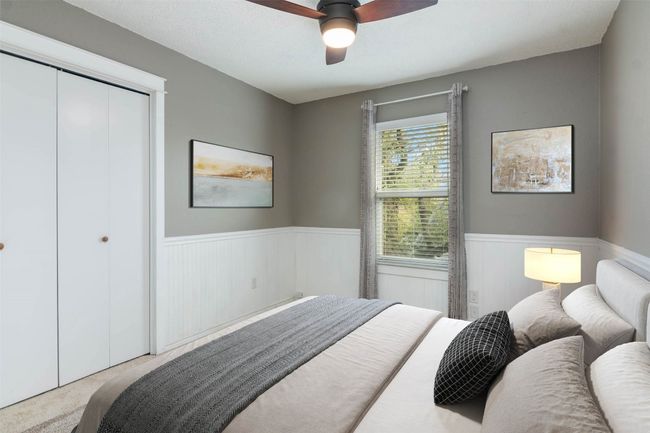Bedroom with wainscoting, carpet floors, a closet, and ceiling fan | Image 6