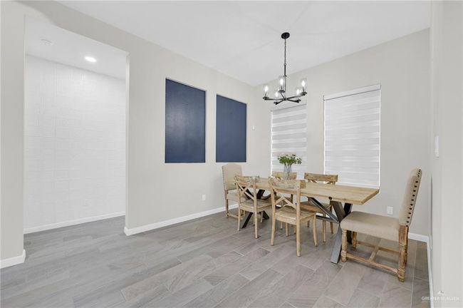 Dining room featuring an inviting chandelier, light wood-style tile flooring, and baseboards | Image 14