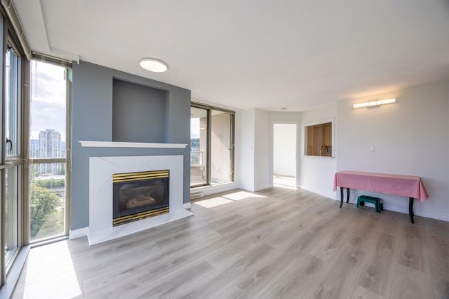 Living room with a fireplace and light wood-style flooring | Image 9
