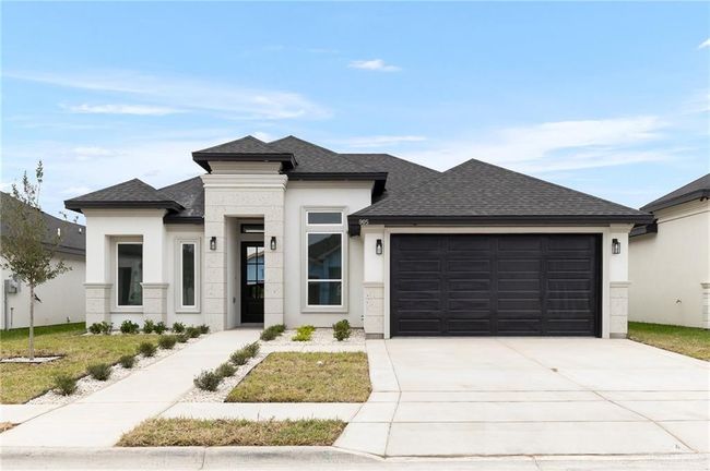 Prairie-style home featuring a garage, roof with shingles, driveway, and stucco siding | Image 15