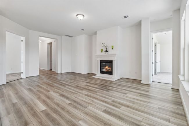 Unfurnished living room with light wood-type flooring and a glass covered fireplace | Image 7