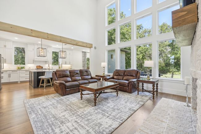 Living room featuring a high ceiling and light wood-style floors | Image 10