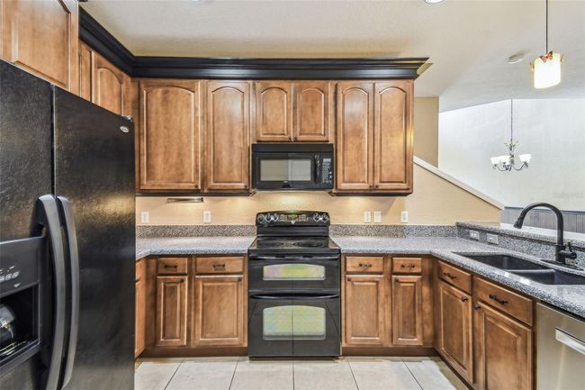 The kitchen boasts 42-inch cabinets with elegant crown molding granite countertops. | Image 9