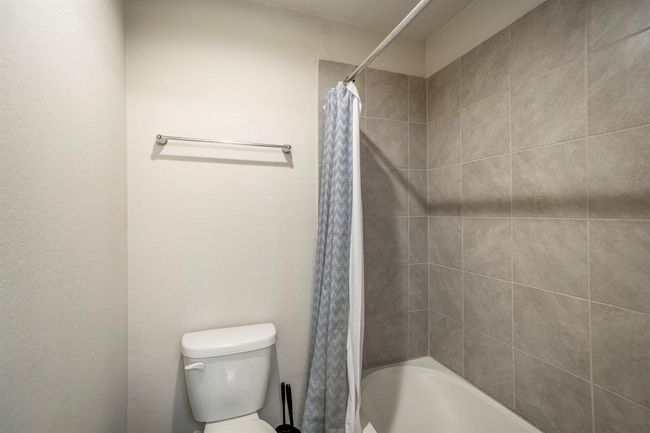The secondary bathroom offer neutral tones, with a tub / shower combo. | Image 30
