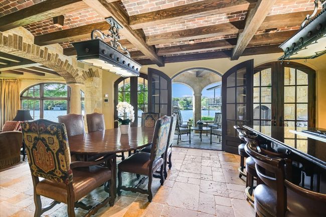 Dining room featuring decorative columns, beam ceiling, brick ceiling, and stone tile floors | Image 12