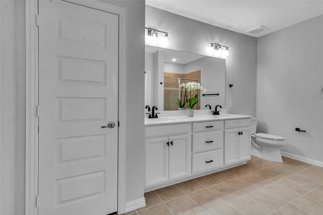 Full bathroom with a sink, double vanity, toilet, tile patterned floors, and visible vents | Image 22