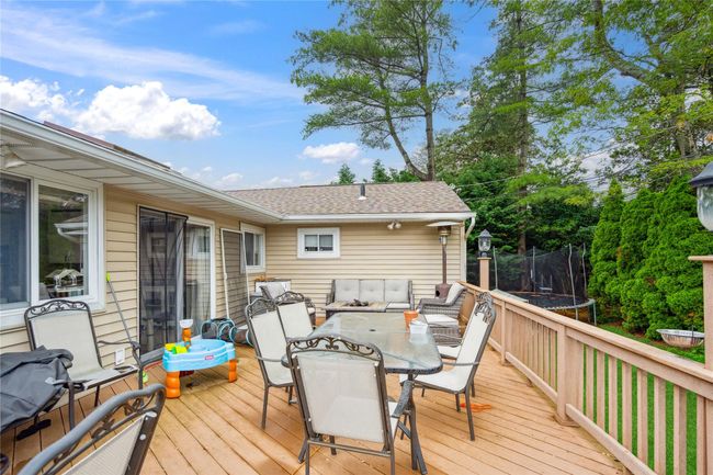 Deck featuring a trampoline and outdoor dining area | Image 25