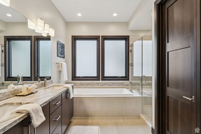Bathroom featuring a bath, double vanity, and a shower stall | Image 35