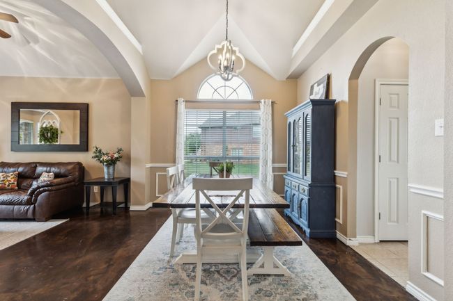 Dining area with arched walkways, ceiling fan with notable chandelier, and vaulted ceiling | Image 5