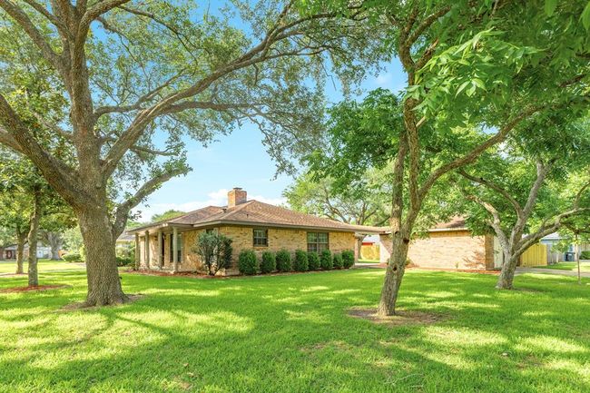One story custom built brick ranch on a large corner lot, centrally located in the desirable Pearland community. The canopies from the tall trees provide shade from our Texas sun. Sit an relax with your favorite beverage on the expansive porch. | Image 34