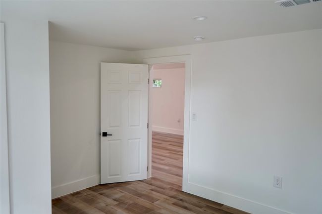 Spare room with wood finished floors and a smoke detector | Image 10