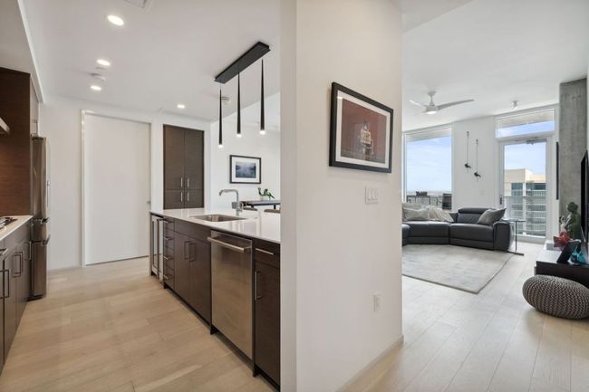 Kitchen featuring stainless steel appliances, a sink, dark brown cabinets, modern cabinets, and recessed lighting | Image 7