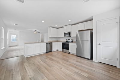 Kitchen includes granite countertops, luxury vinyl plank flooring, 36” upper cabinets with crown molding, a full suite of stainless-steel Whirlpool appliances – including refrigerator with ice maker, recessed lighting, and a large single basin sink. | Image 2