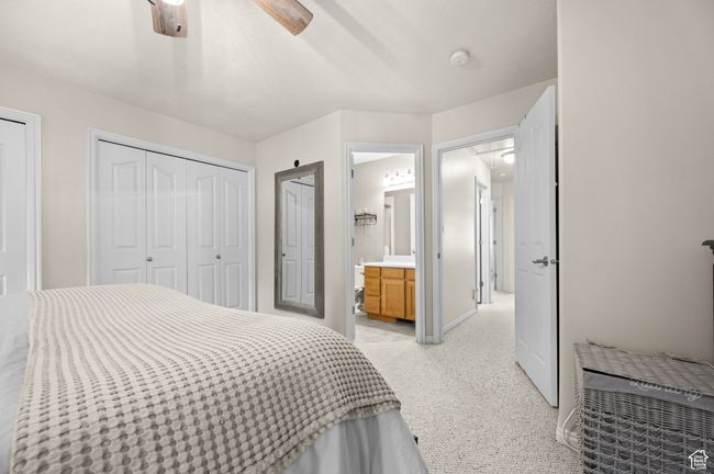 Bedroom with light colored carpet, ensuite bath, ceiling fan, and attic access | Image 18