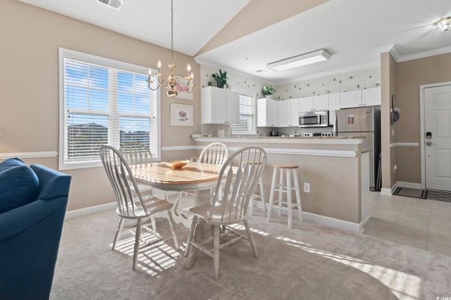 Dining space featuring ornamental molding, a chandelier, baseboards, and light carpet | Image 9