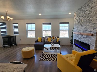 Living room with a textured ceiling, dark hardwood / wood-style floors, and a fireplace | Image 3