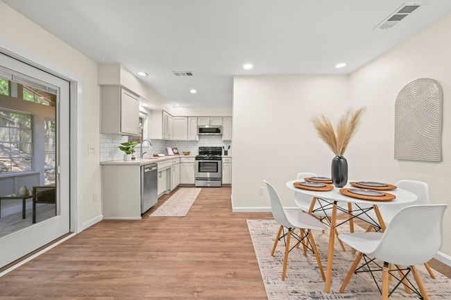 The dining room seamlessly connects to the kitchen and features French doors leading to the sunroom. | Image 9